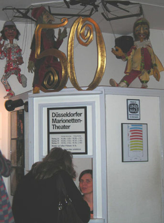 Eine Frau steht an der Theaterkasse.