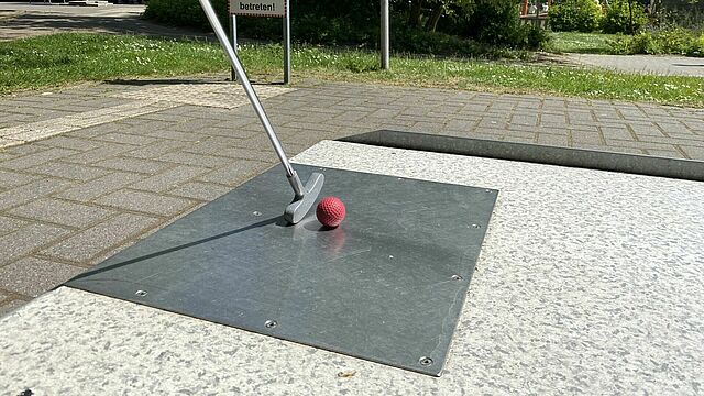 Minigolfschläger mit rotem Ball