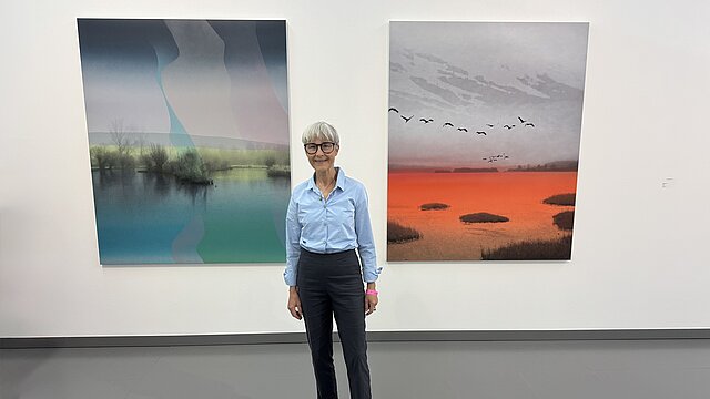 Frau steht vor zwei Bildern