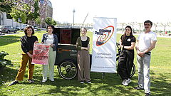 Die Veranstalter zeigen das Plakat zum Event