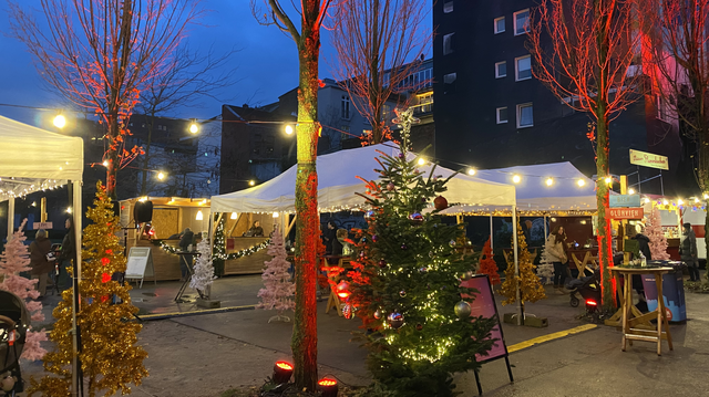 Zelte und bunte Bäume auf dem Weihnachtsmarkt