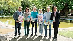 Menschen halten Plakate für die Bewerbung der Düsselfeiren 2024