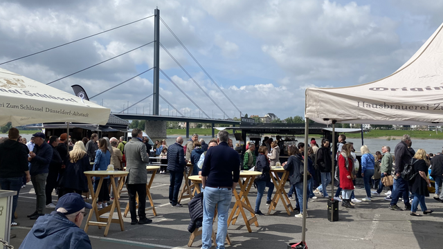 Menschen stehen an Stehtischen 