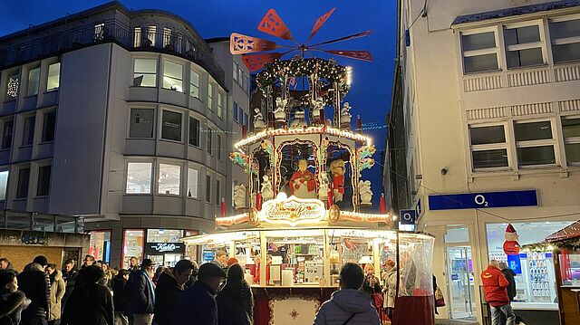 Die Glühweinpyramide und vorbeilaufende Menschen.