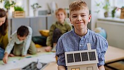 Junge mit einem Modellhaus