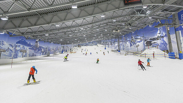 Menschen auf Skiern und Snowboard in der Skihalle Neuss