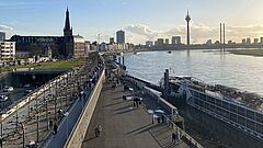 Menschen spazieren über die Rheinpromenade