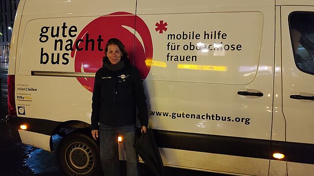 Frau steht vor einem Bus