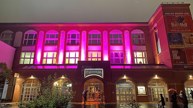Das Capitol Theater leuchtet pink am Abend.
