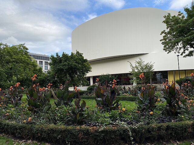 Das Schauspielhaus in der Rückansicht mit Blumenbeet davor.
