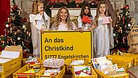 Das Christkind mit seinen Helfern und Post im Vordergrund.
