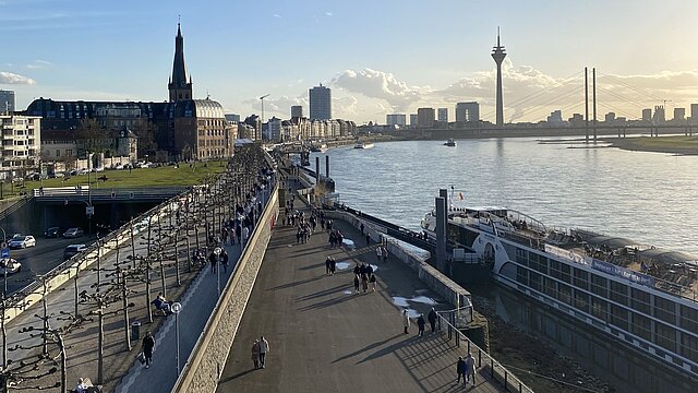 Menschen spazieren entlang der Rheinpromenade