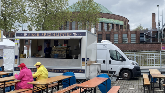 Ein Fischstand mit Tischen davor