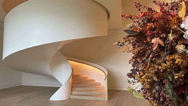 Eine Wendeltreppe mit Blumenarrangement davor