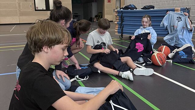 Kinder schauen sich ihre Trikots an