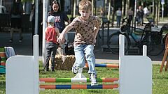 Junge springt über Hindernis