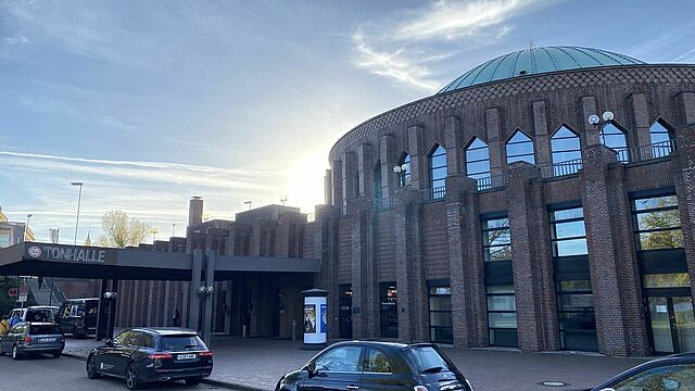 Der Eingang der Tonhalle mit Autos davor.