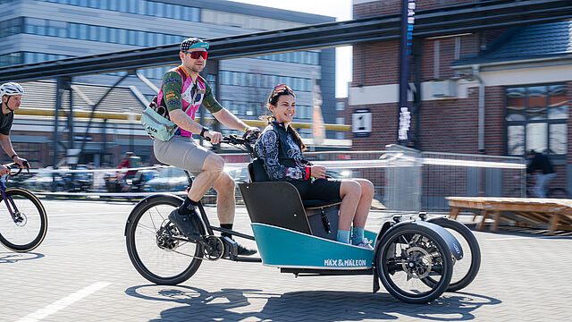 Zwei Menschen auf einem Lastenrad