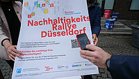 Mobiltelefon scannt einen QR Code auf einem Plakat
