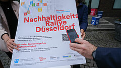 Mobiltelefon scannt einen QR Code auf einem Plakat